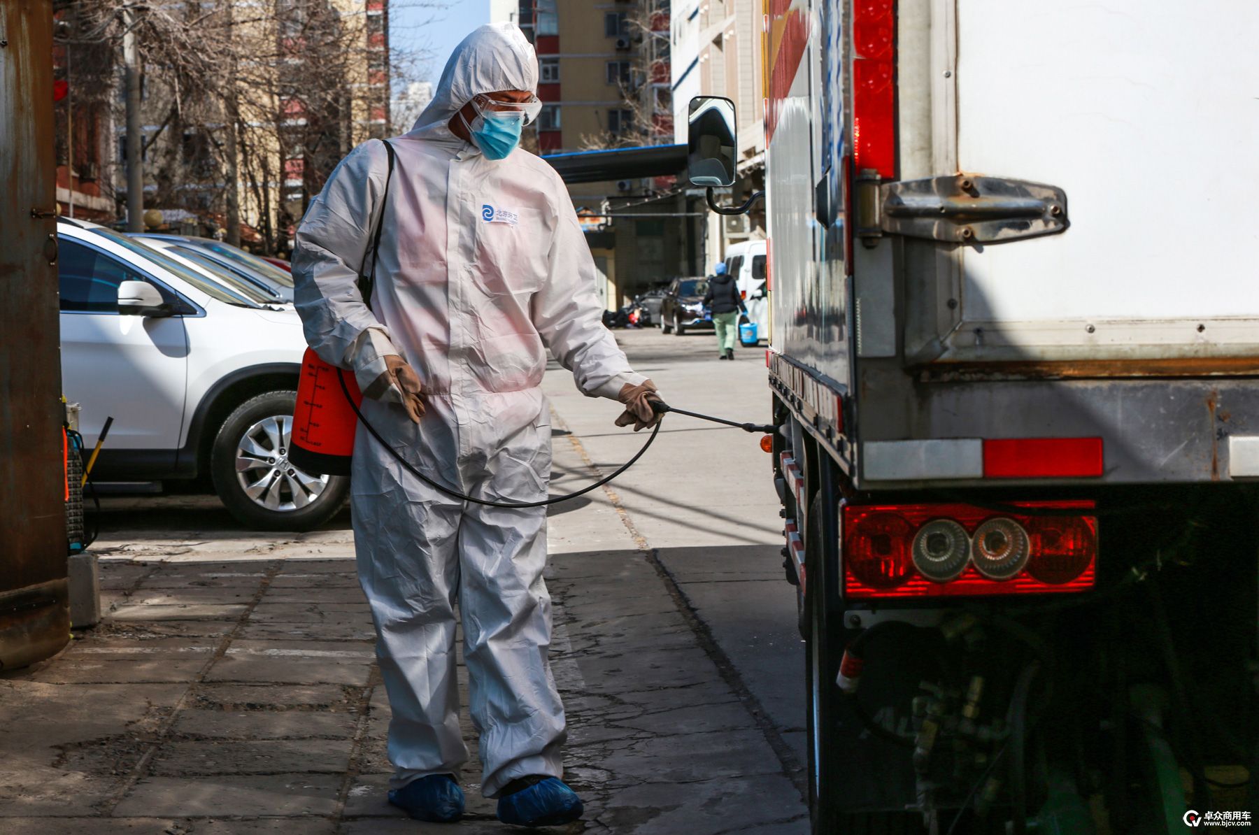 图7-将医疗废物装车后，医废中心职工对垃圾清运车的车身进行消毒作业.jpg